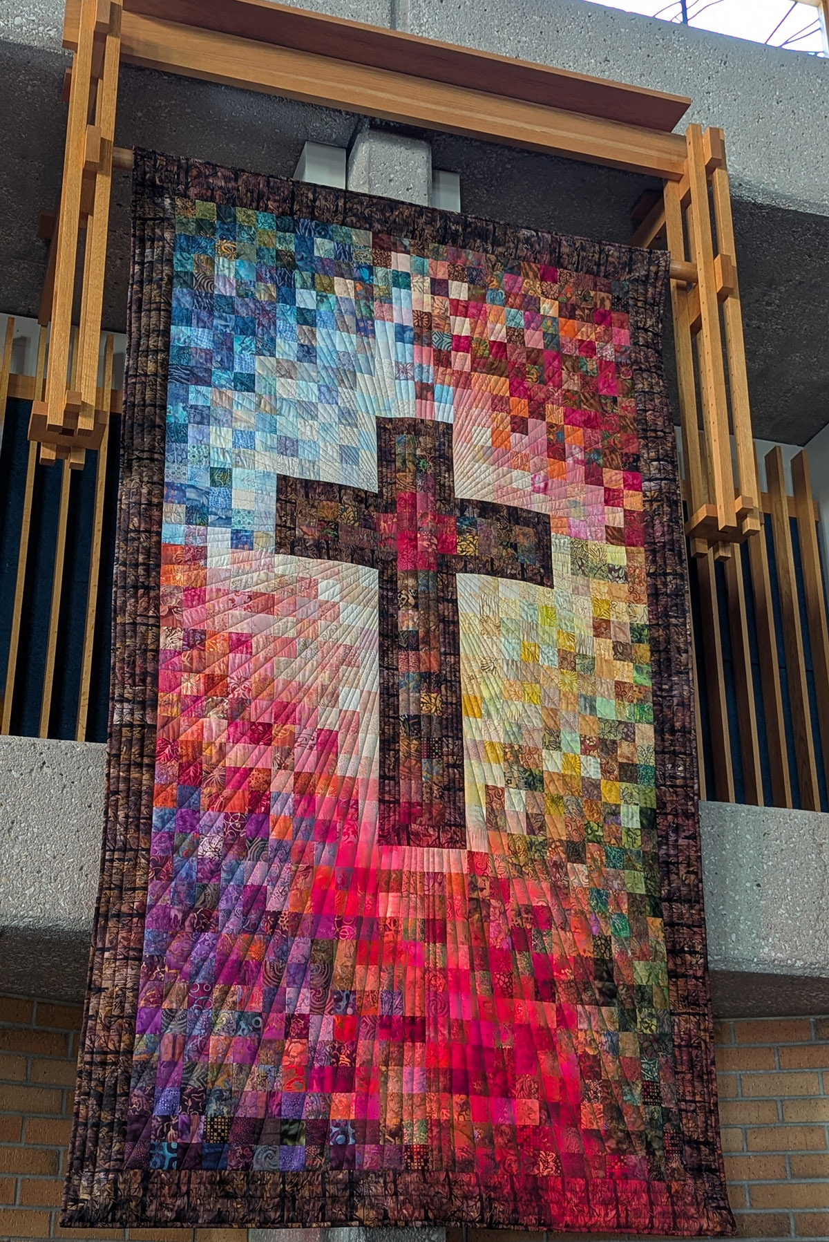 Bunter Quilt mit Darstellung eines Kreuzes