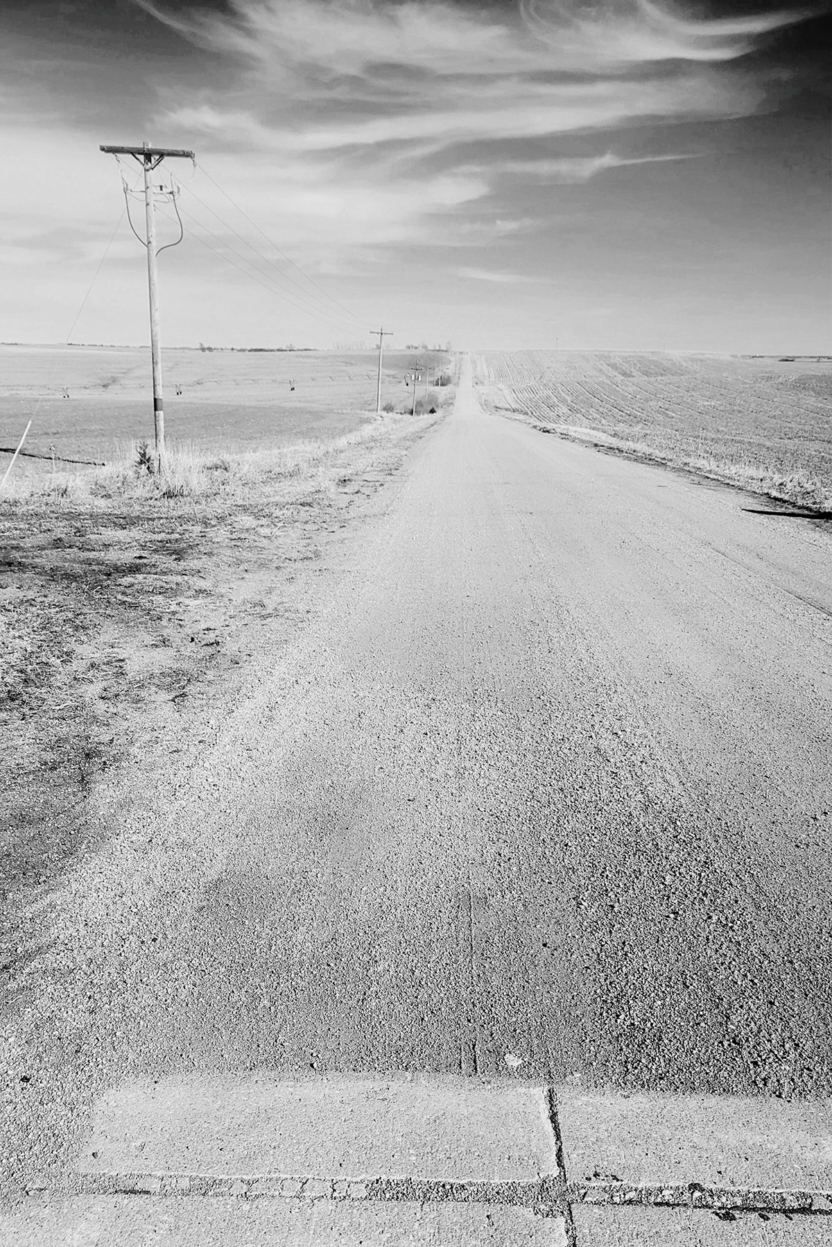 Schwarzweiß-Aufnahme von Straße, die in den Horizont führt