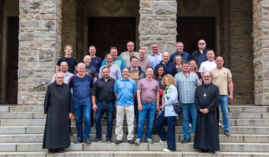 Gruppenfoto der ehemaligen Auszubildenden auf der Treppe der Abteikirche
