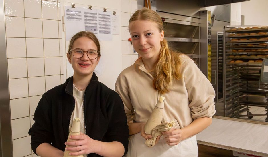 Zwei Mädchen mit Spritztüllen in der Bäckerei